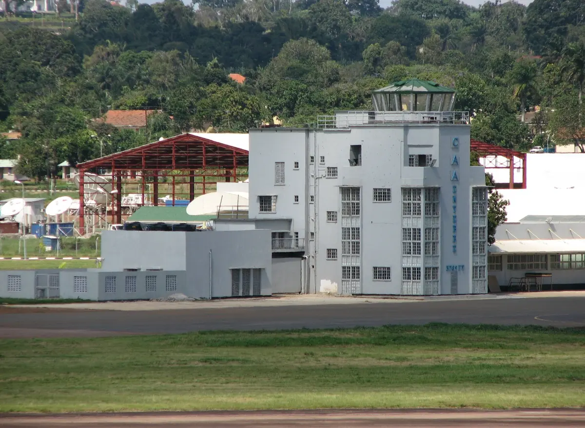 Old control tower and terminal buildings at Entebbe airport among green trees