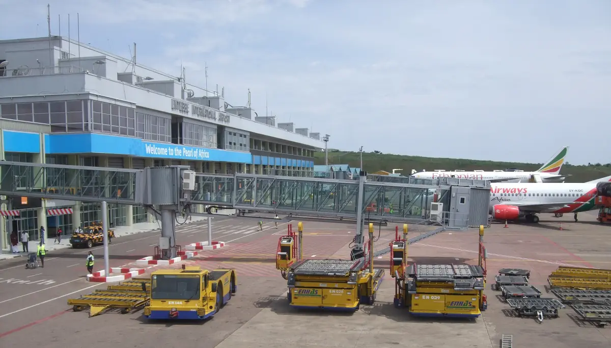 Passenger terminal and apron with aircraft and baggage carts at Entebbe airport