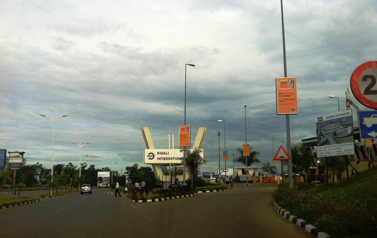 Approach road and entrance gate to Kigali International Airport under cloudy skies