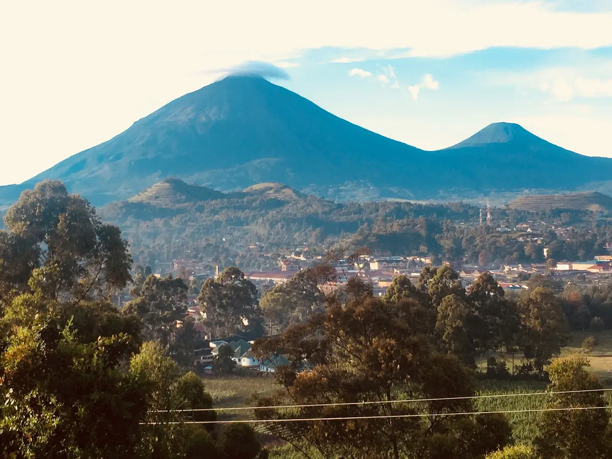 Mount Muhabura and Mount Gahinga rising above hills and a town