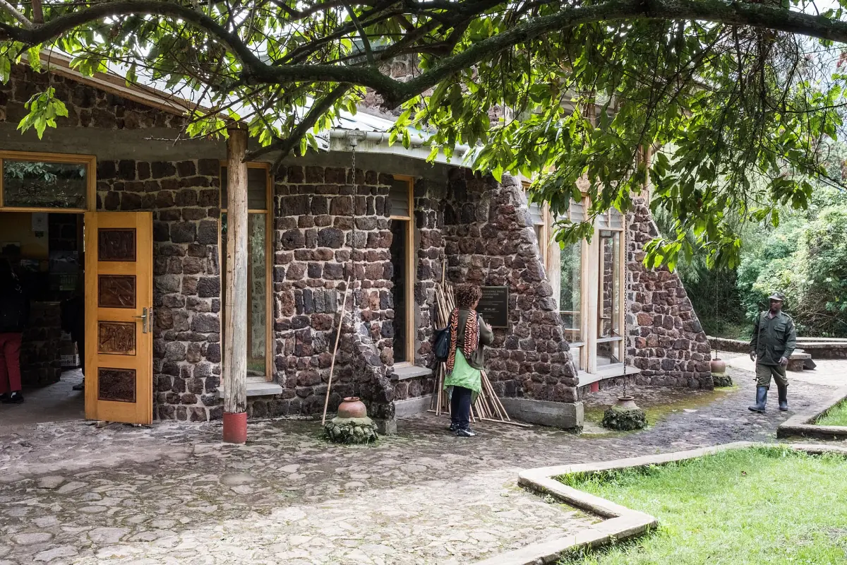Stone visitor centre with wooden doors and a paved path in Mgahinga