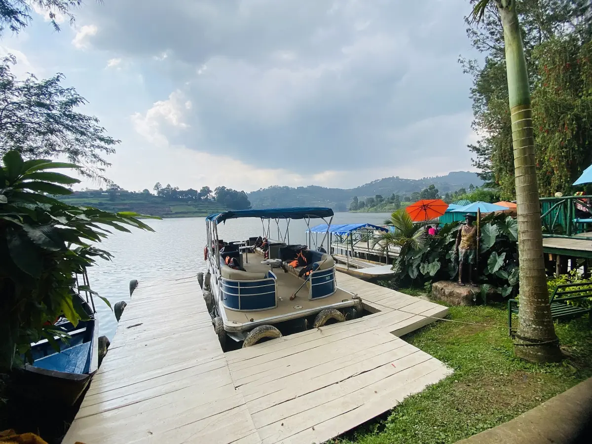 Wooden jetty with small motor boats on the shore of Lake Bunyonyi